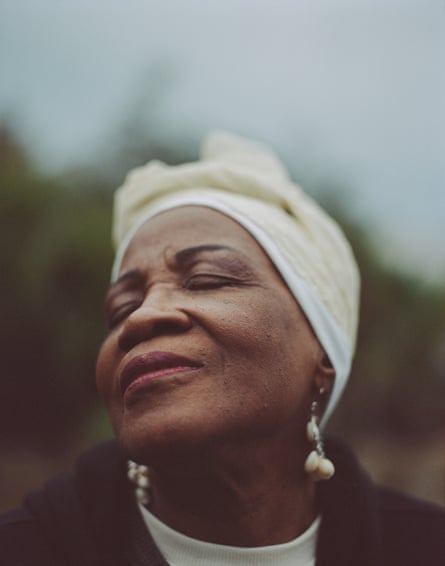 a portrait of a woman raising her face and smiling slightly