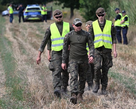 Members of Polish military and police secure the area of a cornfield where an unidentified object fell in Osiny, eastern Poland.