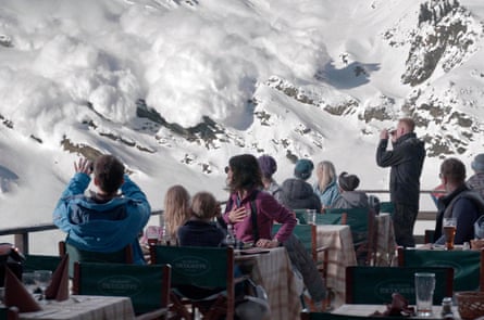 People having dinner watching an avalanche heading down a snowy mountain