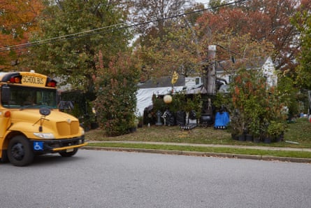 a school bus drives past a home with Halloween decorations covered in tarp before Halloween