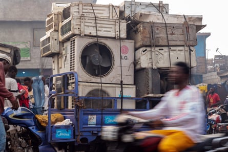 Waste air conditioners being transported on a three-wheeled motorcycle