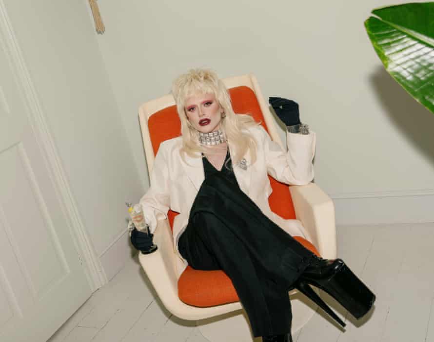 Bimini Bon Boulash sitting in a futuristic armchair