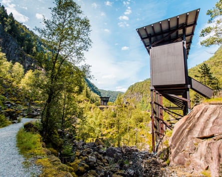 A raised wooden toilet with solar panel roof overlooks a forested valley at Allmannajuvet.