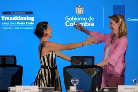 Torres and Van Veldhoven stand and make to embrace on stage