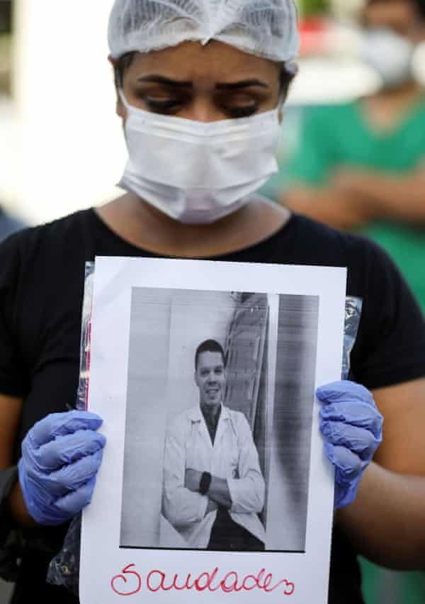 A healthcare worker wearing a protective face mask pays tribute to co-workers that have died from Covid-19 in front of the 28 de Agosto hospital in Manaus, on Monday. The sign reads: ‘Miss you.’