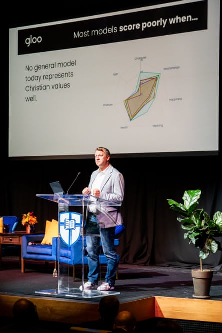 A man speaking on a stage while presenting.