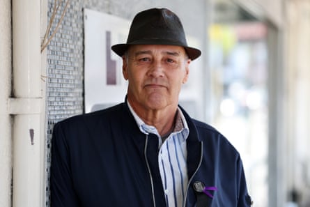 Nigel Higgins, wearing a hat and bomber jacket, leans against a wall