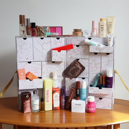 Cult Beauty Signature Edition Advent calendar open on a table, with its beauty products arranged alongside it