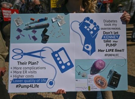 A protester holding a placard saying: ‘Diabetes took my daughter’s pancreas. Don’t let [Alberta [premier] Kenney take her pump!’
