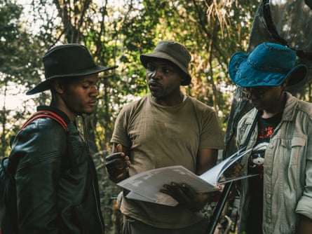 Dr Ruffin Mpanga speaks to Daniel Mukabila as he holds open a folder of documents