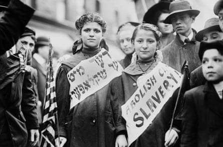 people wear sashes in Yiddish and English that read ‘abolish child slavery’