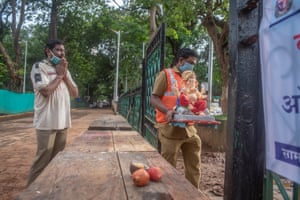A devotee pays tribute and prays to a statue of Lord Ganesh.