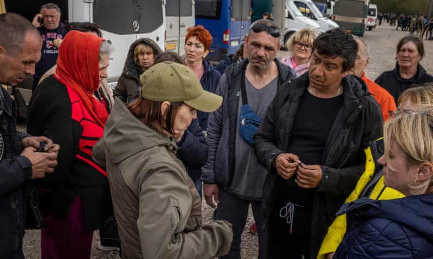 People speak to an official in the car park on the outskirts of Zaporizhzhia