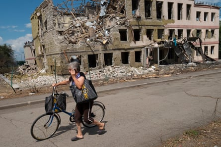A woman walks past past the ruins of a school in Kramatorsk that was hit by a Russian missile.