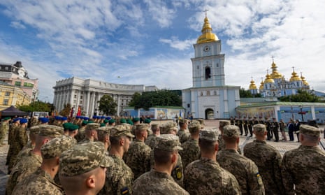 Ukrainian service members attend a ceremony marking Statehood Day