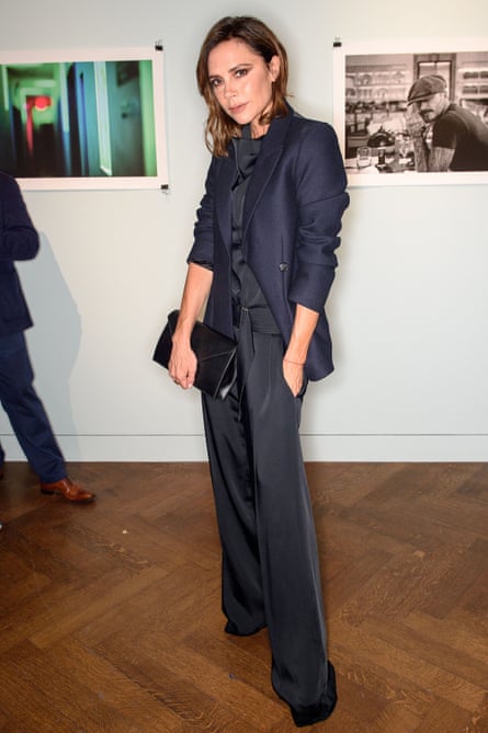 Victoria Beckham wearing flared trousers as part of a dark navy suit
