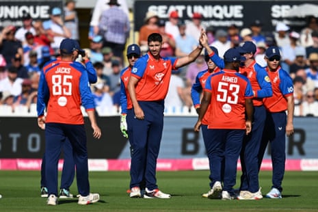 Josh Tongue is congratulated by his England teammates after taking the wicket of Ishan Kishan of India.
