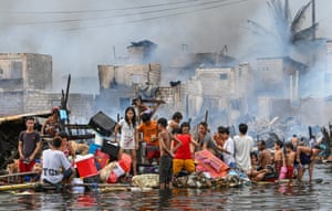 People carry their belongings on a makeshift raft after a fire in Manila, Philippines