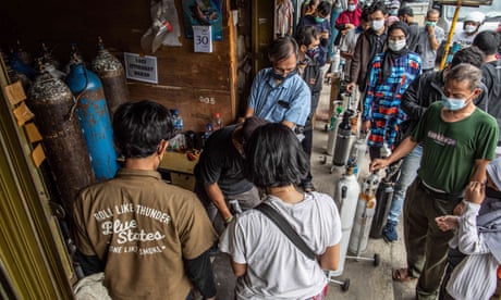 Family members of Covid-19 patients queue to refill oxygen cylinders in the Manggarai area of Jakarta