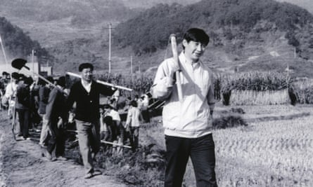Xi with a hoe across his shoulder leads a band of farmers through a field