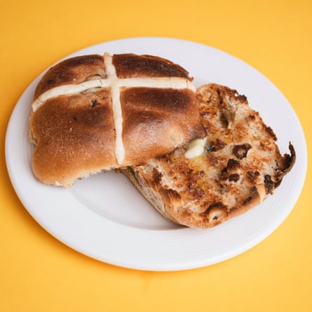 A Waitrose apple and cinnamon hot cross bun, sliced, toasted and buttered, on a white plate