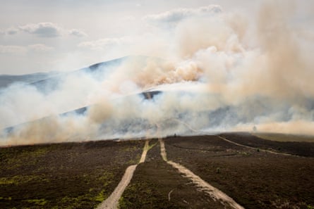Scorched moorland with smoke rising above it