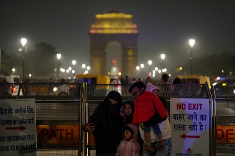 People pose for a photograph in front of India Gate for new year celebrations in New Delhi.