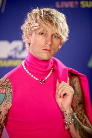 Machine Gun Kelly goes for pink and a pearl necklace.