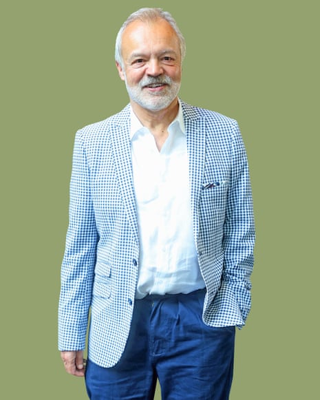 TV presenter Graham Norton in jeans, white shirt and blue and white checked jacket against green background