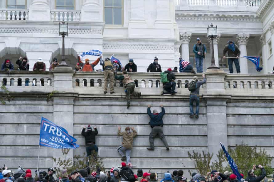 Supporters of then President Donald Trump climb the west wall of the the US Capitol in Washington on 6 January 2021 as part of an effort to overturn the election results.