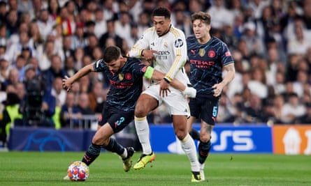 Jude Bellingham is held off by Rúben Dias as John Stones watches on during Real Madrid’s draw with Manchester City