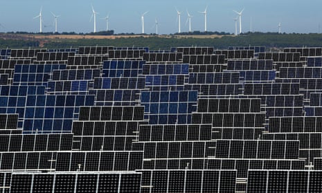 A solar farm with a windfarm in the background in El Bonillo, Spain