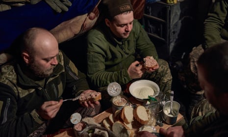 Ukrainian soldiers have a dinner in a shelter along the frontline.