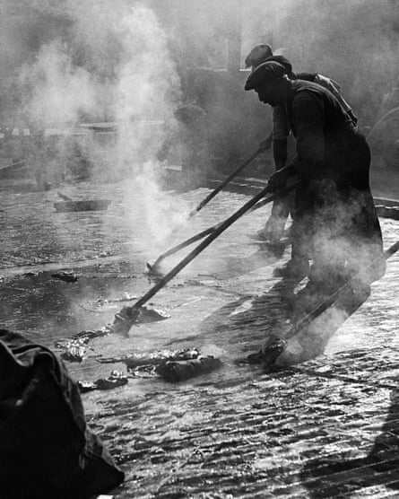An image by Wolfgang Suschitzky of workers applying asphalt to the surface of Charing Cross Road, London, in the 1930s