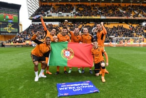 The group of players hold the Portuguese flag as they celebrate