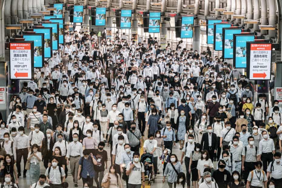 Commuters wear masks at a train station in Tokyo on July 28, a day after the city reported a record 2,848 new daily cases of Covid-19 coronavirus.