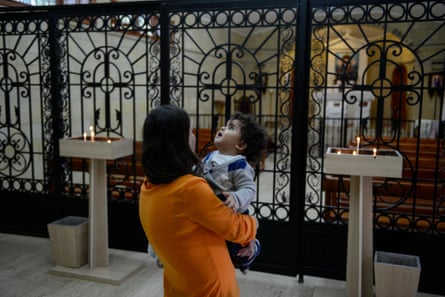 Inside the Armenian church at Vakıflı, mother and baby standing at grille in front of the altar.