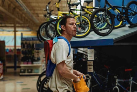 Channing Tatum as Jeffrey Manchester stands by a bicycle display in a toy shop.