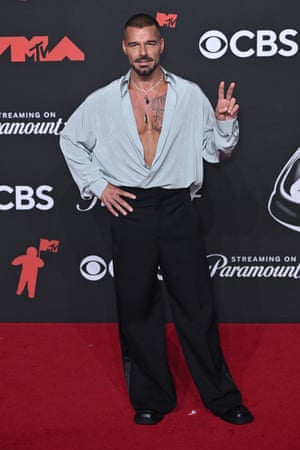 Ricky Martin is swashbuckling for peace in an open fronted silk shirt, paired with a goatee and jewellery.