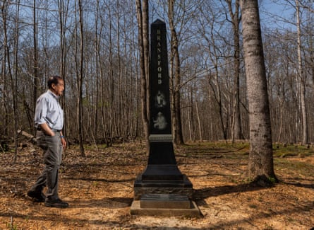 a man stands in front of an outdoor monument