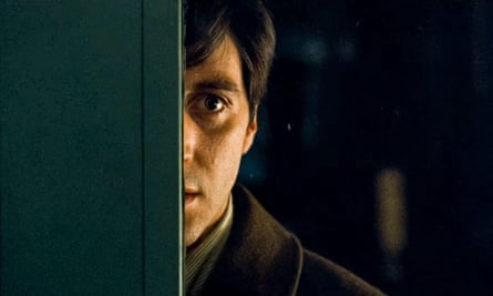 Half of Al Pacino’s face seen peeking through the glass panel of a door
