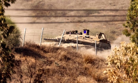 An Israeli tank moves at a position near the border with the Gaza Strip in southern Israel on Friday
