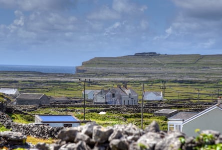 The flat landscape of Inishmore island, with small cottages and stone walls