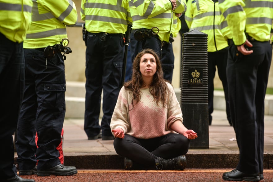 A climate change activist is surrounded by police officers outside the Treasury building this month.