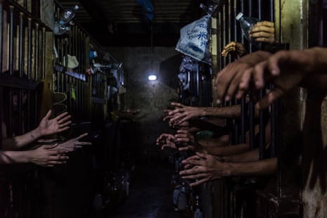 Prisoners beg for food and water at their cells in a police station. Many said they had regular jobs but turned to crime because of the impossibility of bringing food home