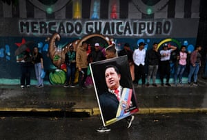 A supporter of President Nicolás Maduro holds an image of the late Venezuelan president Hugo Chavez