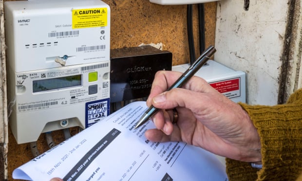 A women checks her electricity meter against an energy bill.