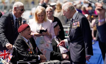 King Charles smiling with a military veteran in a wheelchair.