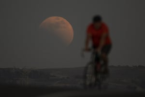 Irwindale, California. The eclipse is seen behind a cyclist
