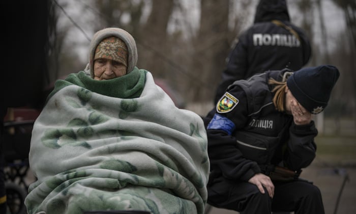 A Ukrainian police officer is overwhelmed by emotion after comforting people evacuated from Irpin on the outskirts of Kyiv.